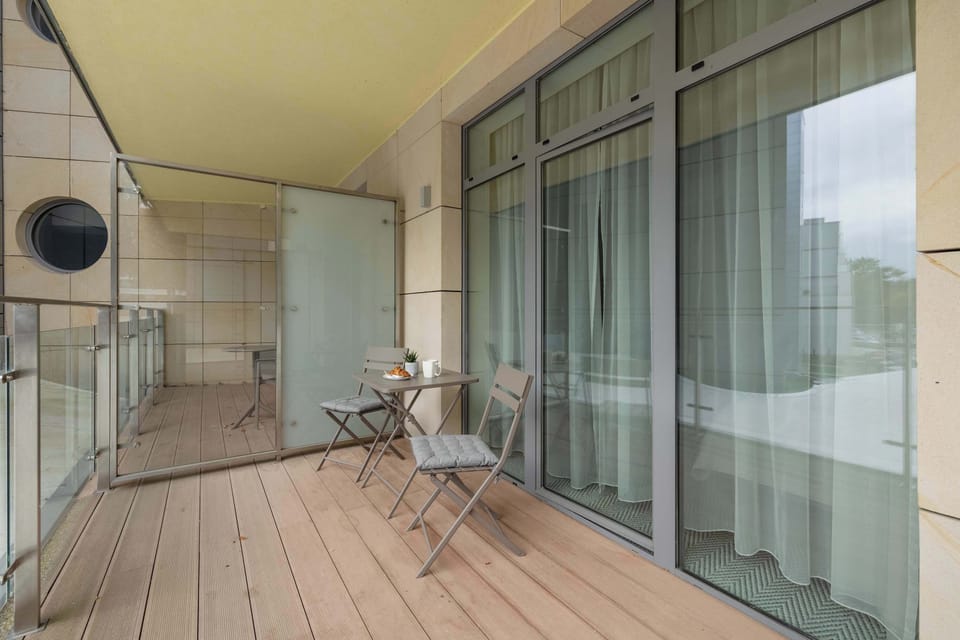 The studio includes access to a small balcony furnished with chairs, ideal for enjoying fresh air and views.