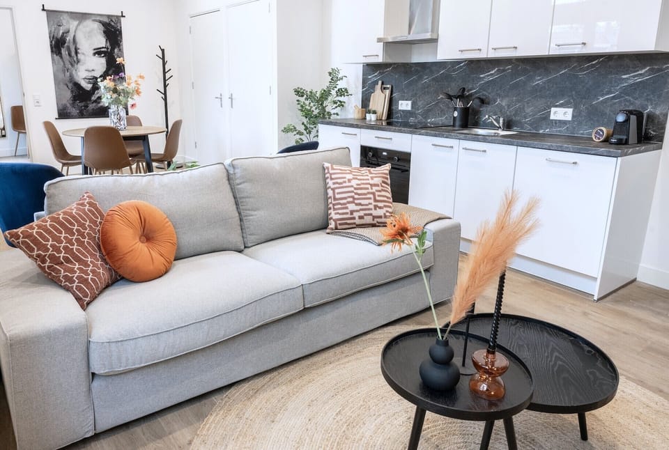 Cozy neutral-toned sofa with pillows – unwind after exploring Beekse Bergen or Tilburg Centrum.