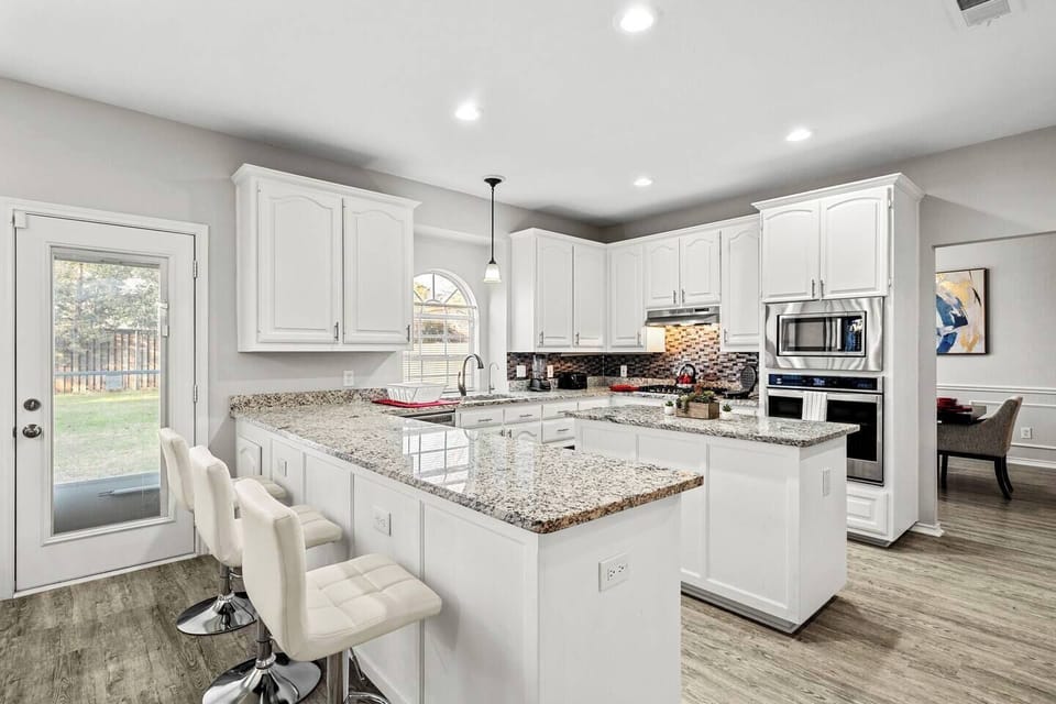 Spacious kitchen with granite countertops, modern appliances, and a breakfast bar. Ideal for family meals during your mid-term stay. Located 15 minutes from Fort Worth Zoo and Sundance Square, and 25 minutes from DFW Airport. Insurance relocations.
