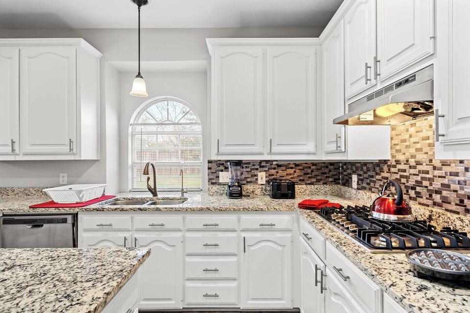 Bright kitchen with granite countertops, stainless steel appliances, and a large window overlooking the backyard. Perfect for meal prep during your mid-term stay. Located 15 minutes from Fort Worth Zoo and Sundance Square, and 25 min to DFW Airport