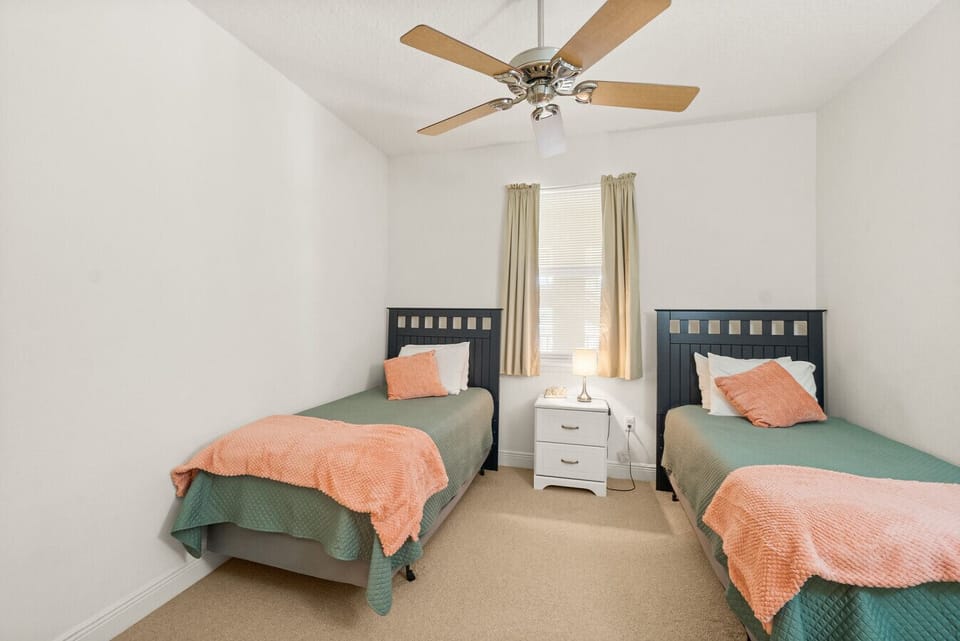 Bright and cheerful twin bedroom with soft linens and plenty of space for a cozy night’s rest.