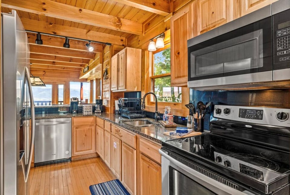 Whip up breakfast with a view or prep dinner for two in this fully stocked kitchen. Stainless steel appliances, granite countertops, and natural wood cabinets blend convenience and cabin charm effortlessly.
