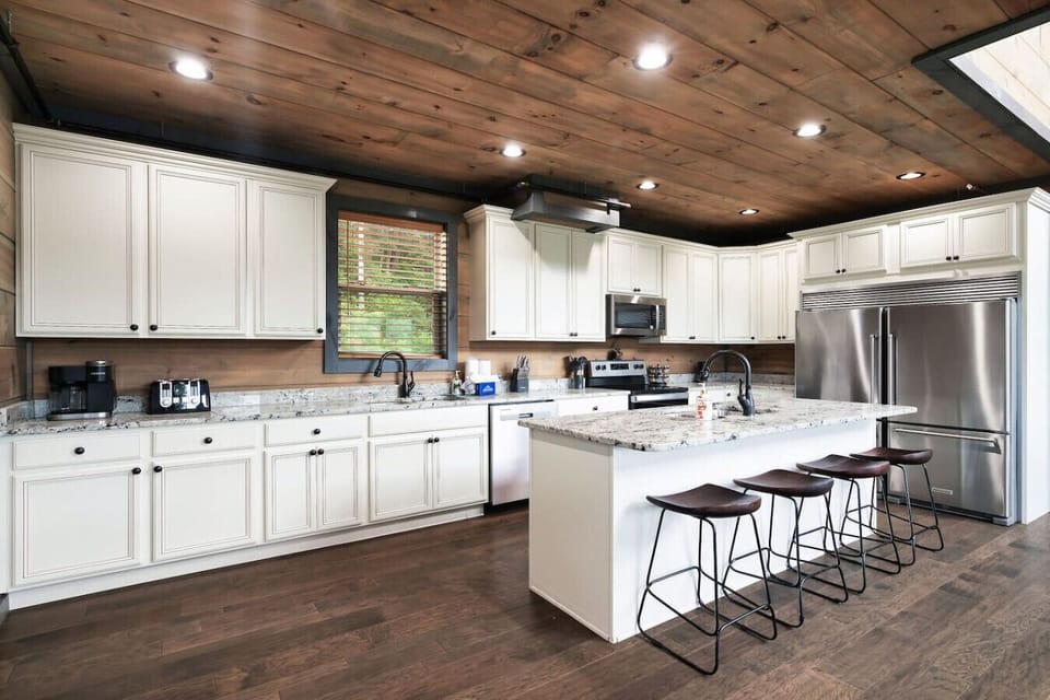 This dreamy kitchen is where mountain mornings begin—granite countertops, rich wood tones, and a spacious island invite you to sip coffee, cook meals, and gather with your group.