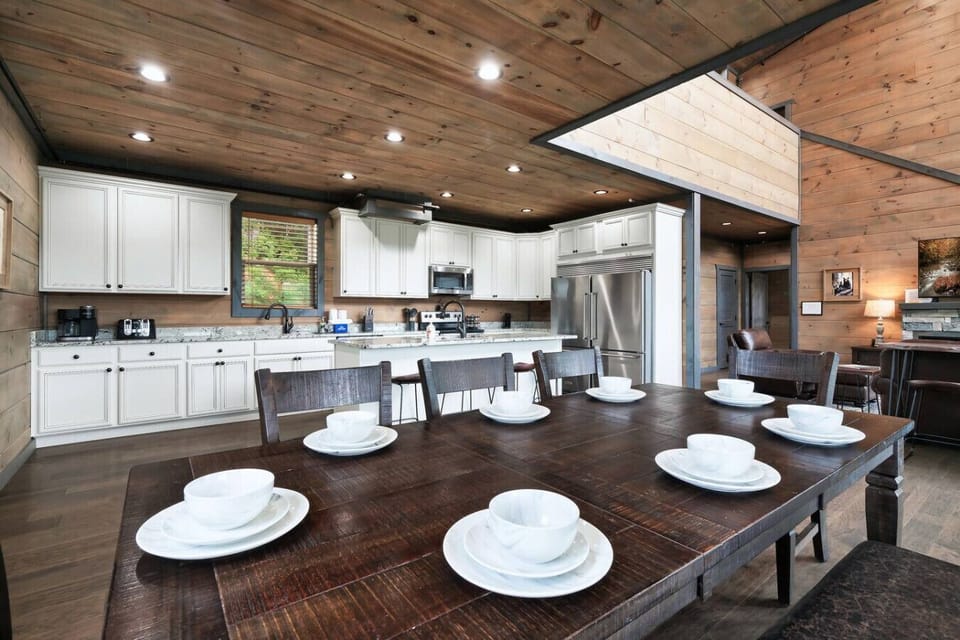 Gather around the oversized dining table for family meals, game nights, or breakfast with a view. The sleek white kitchen with stainless appliances is fully stocked and ready for your favorite recipes.