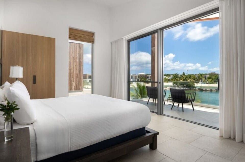 Arrive at a modern villa framed by lush tropical greenery.