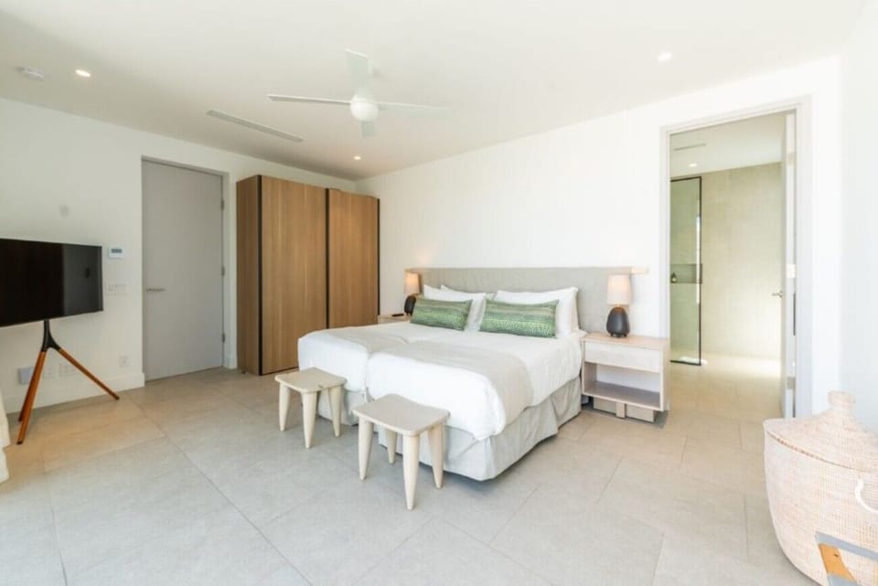 Sink into crisp linens in a breezy, minimalist seaside bedroom.