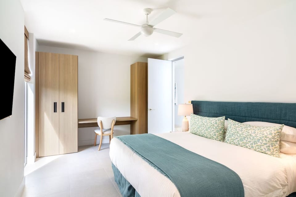 Settle into a serene bedroom with workspace and plush bedding