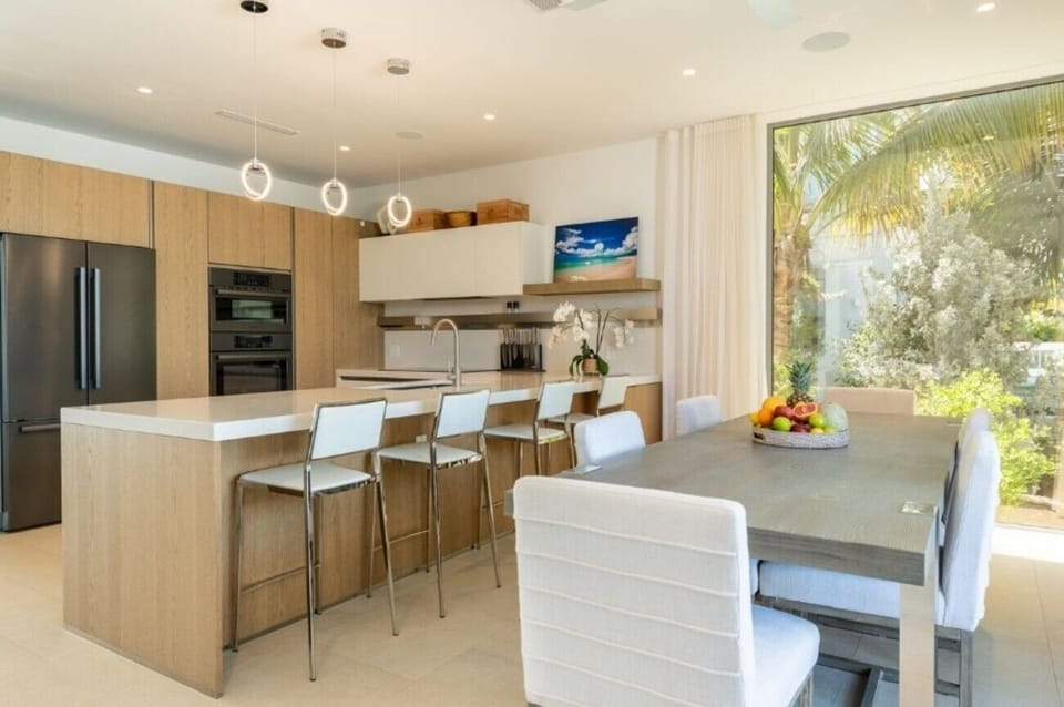 Host lingering meals around a sleek island and dining table.