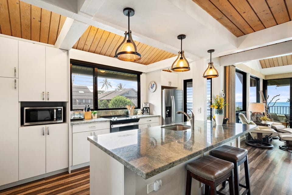 Cook with ease in a spacious kitchen featuring a large island, modern appliances, and stunning views through expansive windows