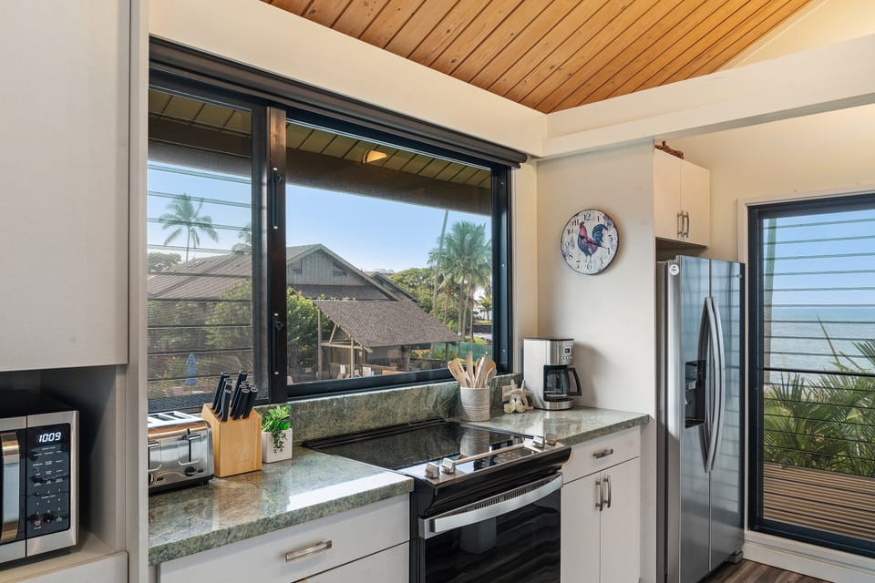Prepare your favorite dishes in a well-equipped kitchen framed by panoramic windows and coastal charm.