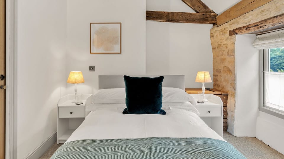 A double bed sits between two bedside tables with lamps.