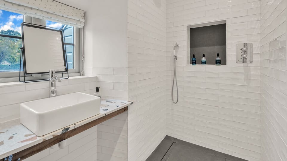 Through a sliding door the en-suite shower room is tucked away.