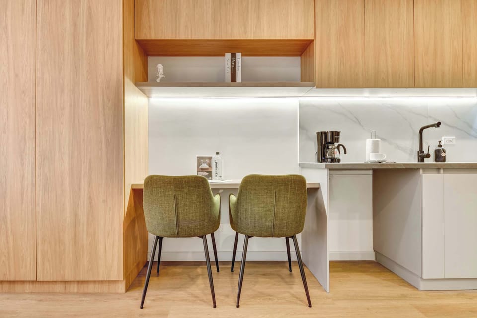 Modern kitchen with bar and two green chairs