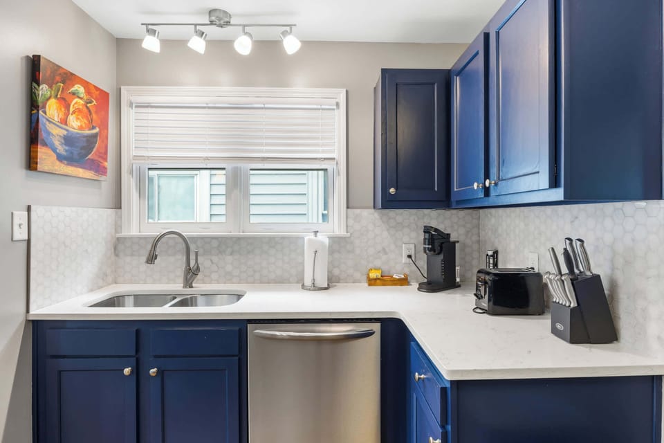 Kitchen: Cook and Connect – Enjoy this inviting kitchen with bold blue cabinetry, sleek finishes, and cozy seating that makes mealtime a delight.