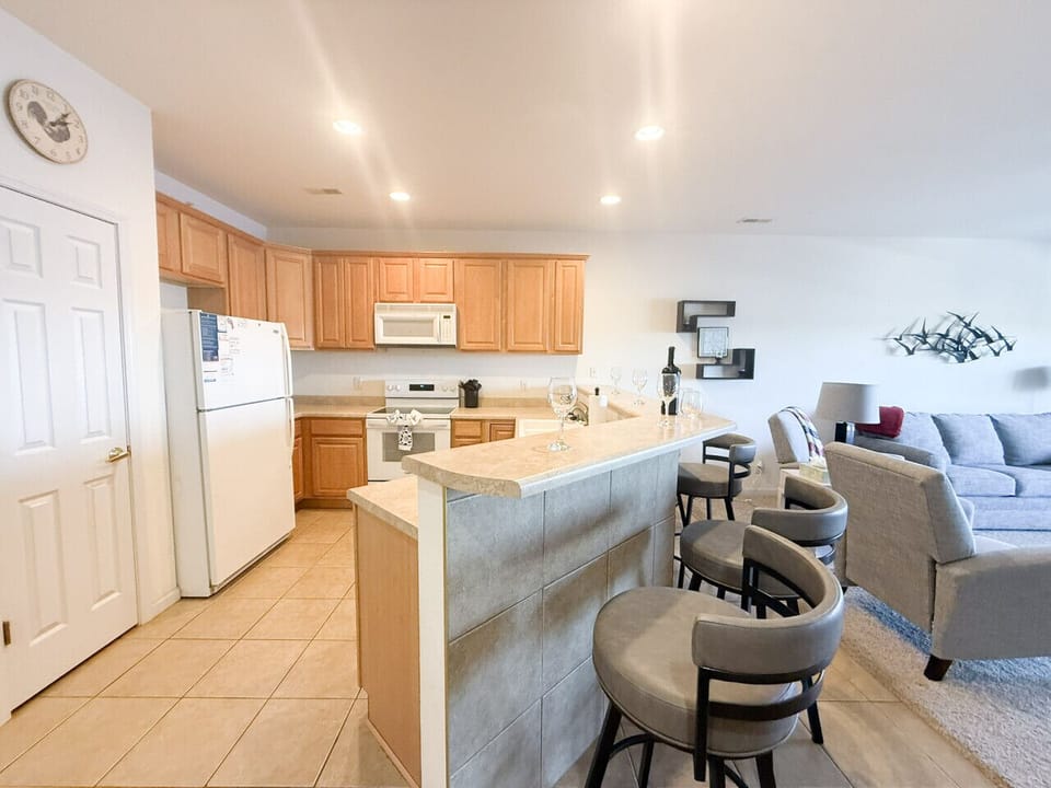 Open-concept kitchen with breakfast bar seating, full appliances, and seamless flow into living space—perfect for entertaining and easy vacation living.
