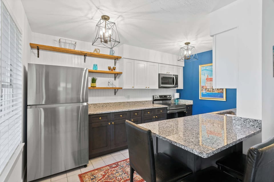 Modern kitchen with elegant granite countertops and full-size appliances.