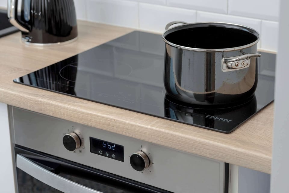 Induction cooktop and appliances – Fully equipped kitchen ready for home cooking.