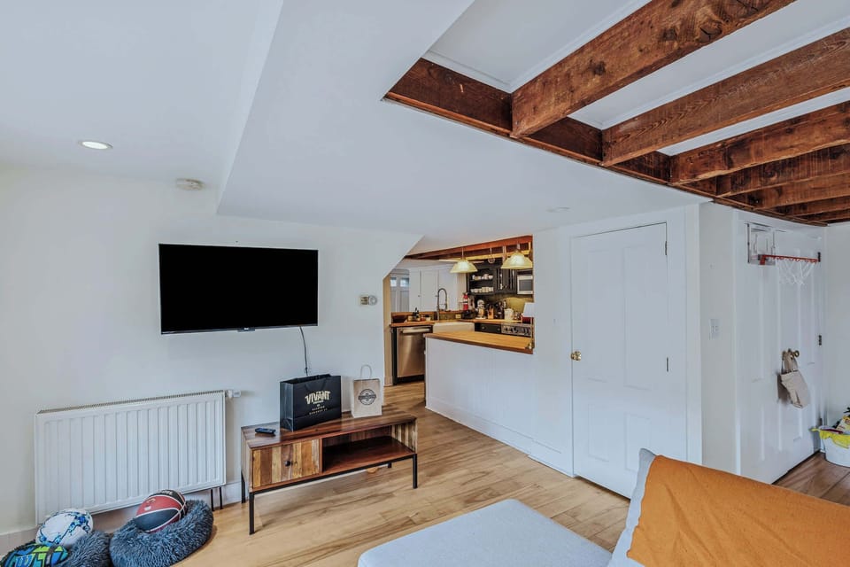 Family room with Smart TV, exposed beams, and indoor basketball hoop for fun