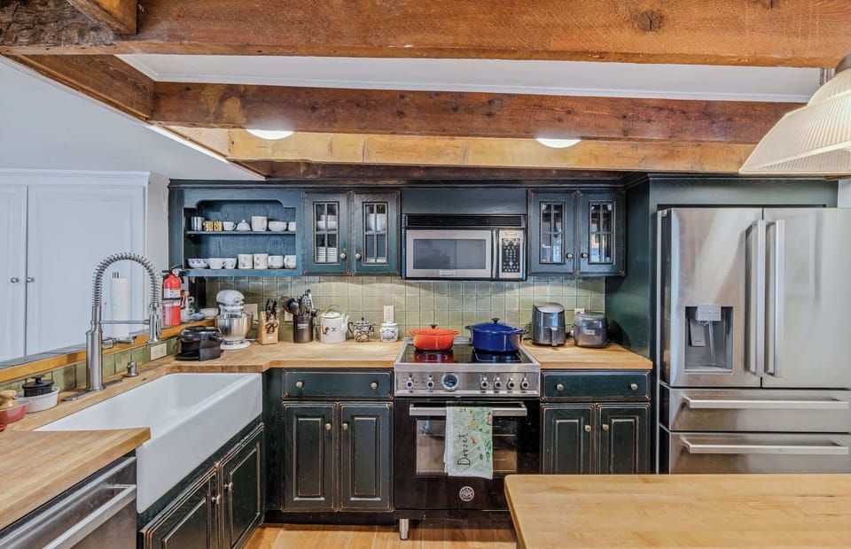 Full kitchen with stainless steel appliances, farmhouse sink, and tile backsplash