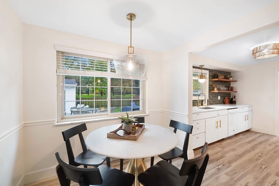 Breakfast room table with seating for five overlooks back patio. 