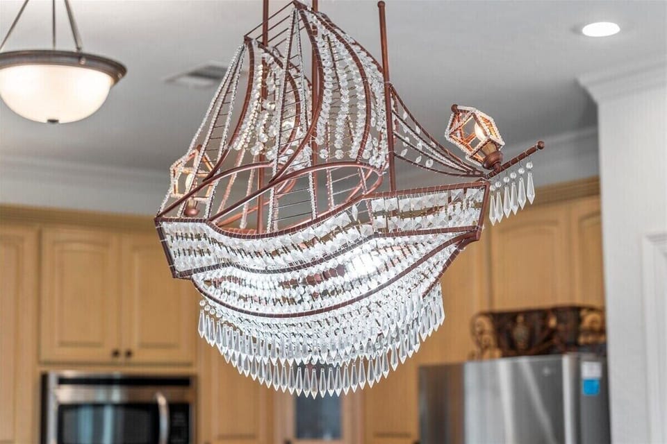 Elegant chandelier detail above kitchen island, adding a touch of luxury to the coastal home.