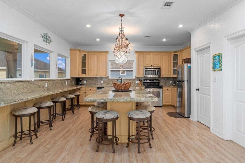 Large kitchen island with bar stools, perfect for group meals and gatherings in this Bolivar Peninsula rental.