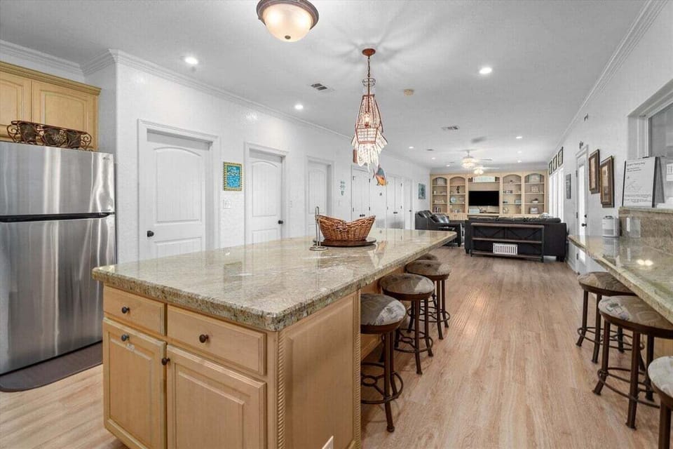 Kitchen with granite countertops, stainless steel appliances, and breakfast bar seating in this fully equipped vacation home.