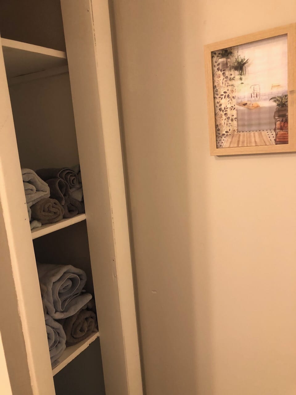 Bathroom linen closet with grey bath towels, hand towels and washcloths