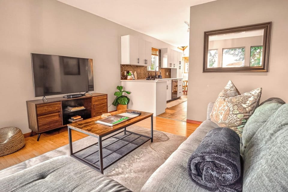 Comfortable living room with smart TV and open flow into the kitchen—perfect for relaxing after a day exploring.