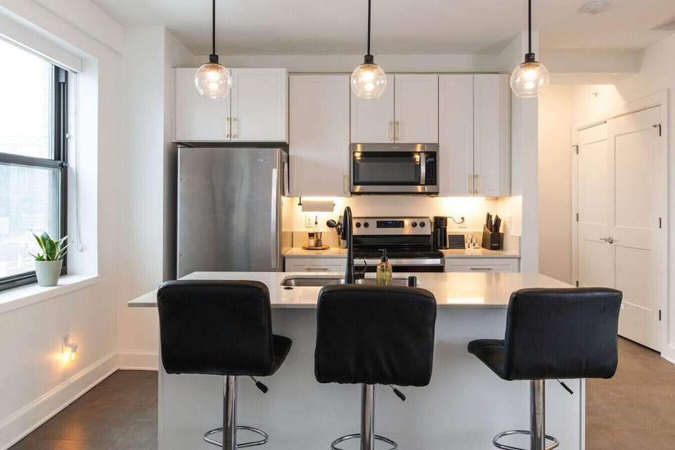 A fully-equipped kitchen featuring high-end finishes and bar seating—everything you need to prep, cook, and refuel