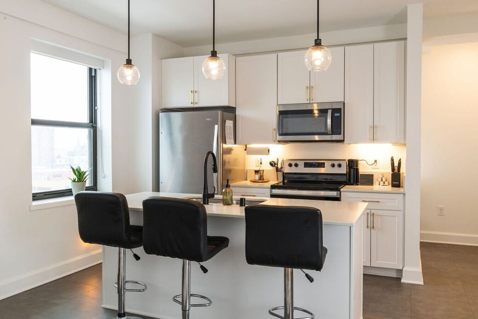 A fully-equipped kitchen featuring high-end finishes and bar seating—everything you need to prep, cook, and refuel