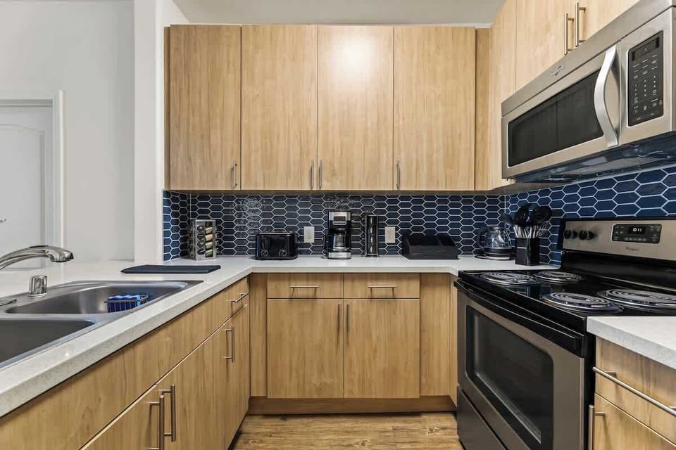 Fully equipped modern kitchen with sleek cabinetry and stainless steel appliances - cook with ease and style.