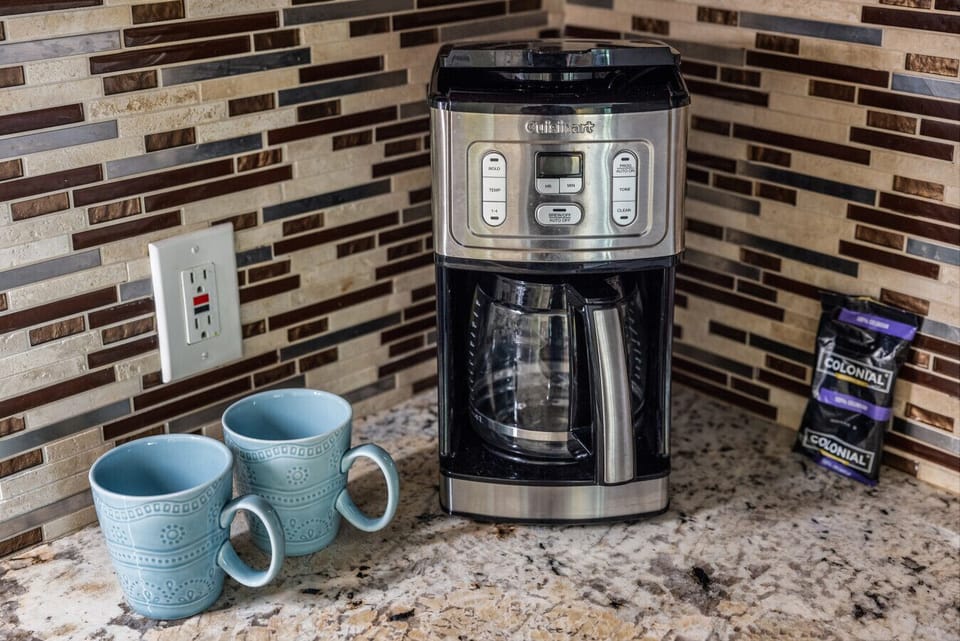 Morning coffee ready w/ a sleek maker & cozy countertop setup.
