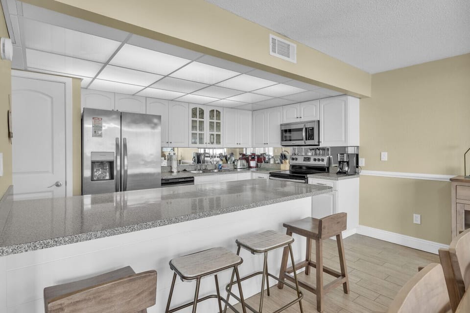 Fully equipped kitchen with stainless appliances and breakfast bar seating