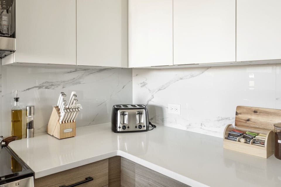 Kitchen with oven, microwave, fridge, dish washer, coffee maker, tea kettle, tea, coffee, mixer, mixing bowls, kitchen utensils, toaster