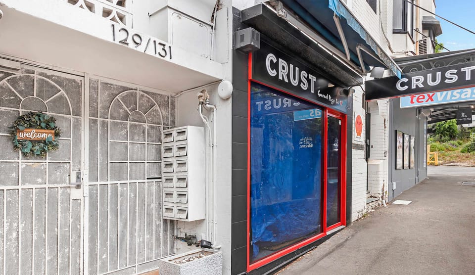 Conveniently located building entrance surrounded by shops and local amenities.