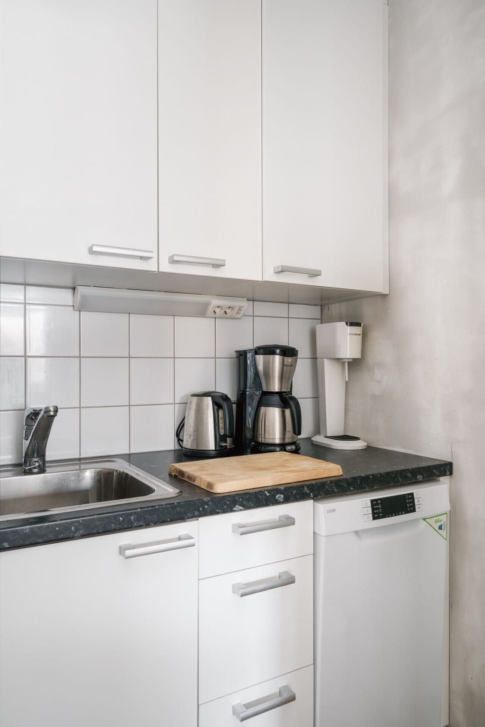 Start your mornings right with the provided coffee maker and kettle in a clean, functional kitchen space.