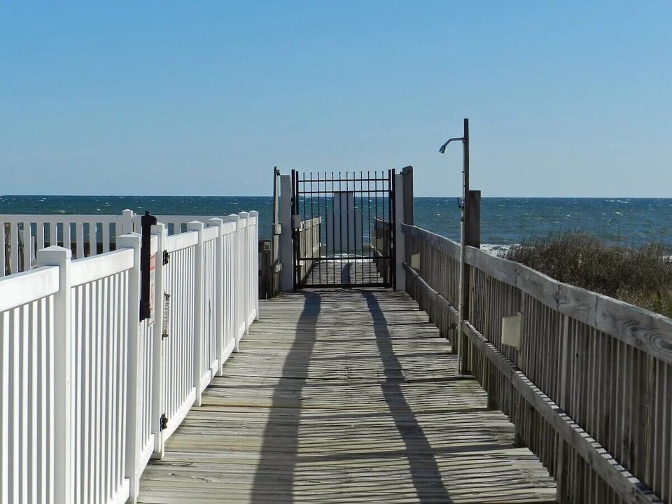 Secure path to the sand! Enjoy nearby pools, tables, and rockers.