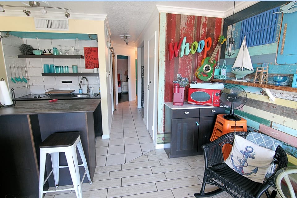Colorful coastal kitchen and living space with fun beach themed decor
