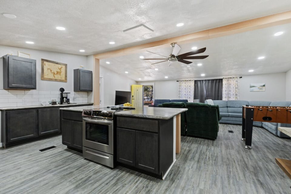 Modern Kitchen | Large Island with Bar Seating | Stainless Steel Appliances | Sleek Gray Cabinets & Subway Tile Backsplash