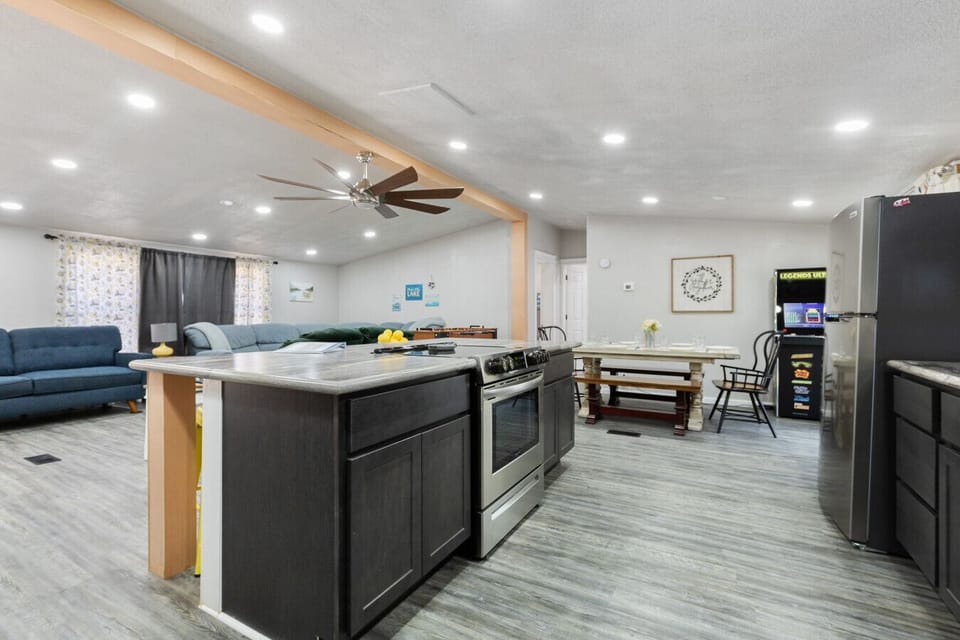 Modern Kitchen | Large Island with Bar Seating | Stainless Steel Appliances | Sleek Gray Cabinets & Subway Tile Backsplash