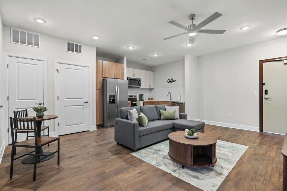 - Open living layout with comfy sofa, bright decor, and full kitchen access
- Perfect for gatherings, relaxing evenings, and flexible extended-stay setups
- Welcoming apartment space offering comfort, warmth, and easy city living