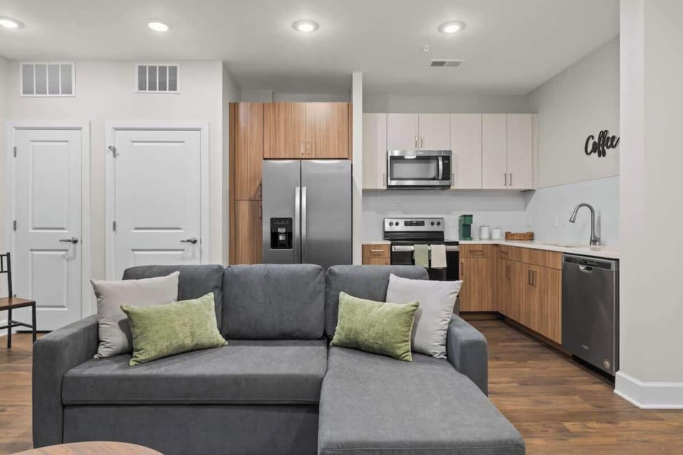 - Modern living room with cozy sofa, warm wood accents, and open kitchen layout
- Perfect for relaxing, streaming, and enjoying a comfortable apartment stay
- Bright open space designed for easy meals, quiet evenings, and longer visits
