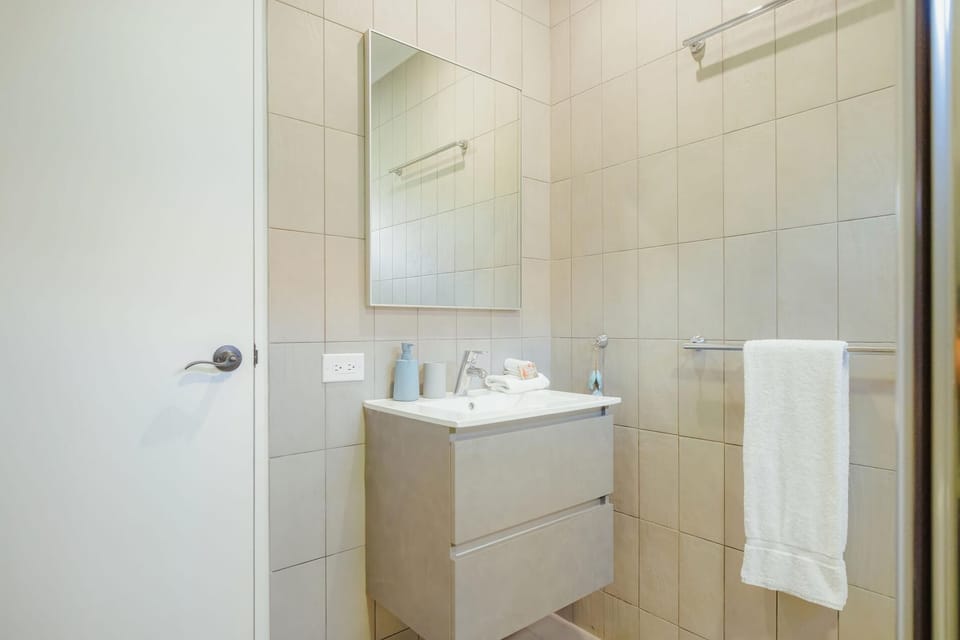 Relax in a modern bathroom with rainfall shower, full vanity, and complimentary toiletries.