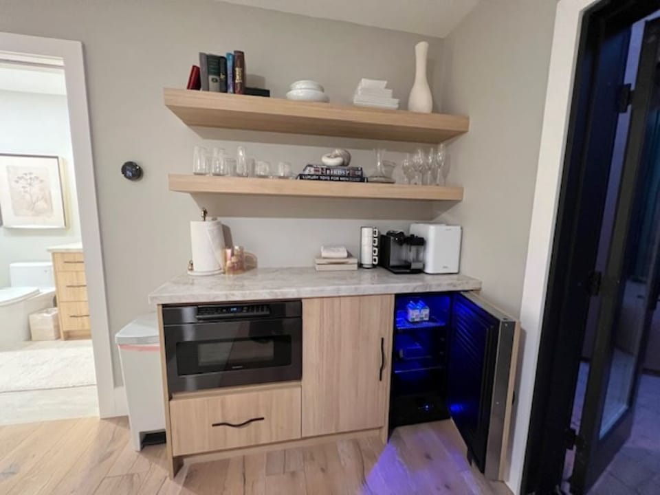 Kitchen with mini fridge, microwave, ice maker, coffee maker, and full utensils