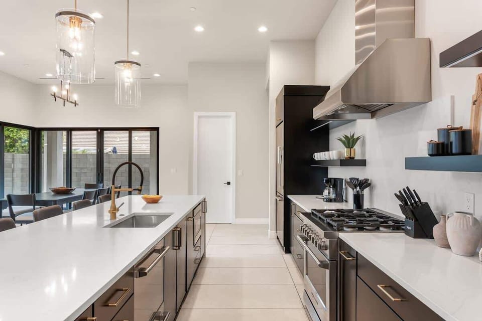 Unit 1: Large open-concept kitchen with brand new stainless steel appliances, quartz counter tops, large island with breakfast bar seating, and designer decor.