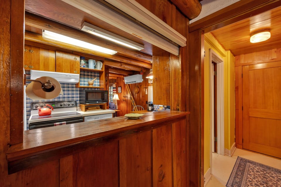 Serving counter opening with access to kitchen and entry corridor.