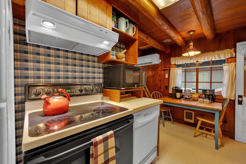 Cozy kitchen corner with stove, breakfast nook & charming window-side dining space.