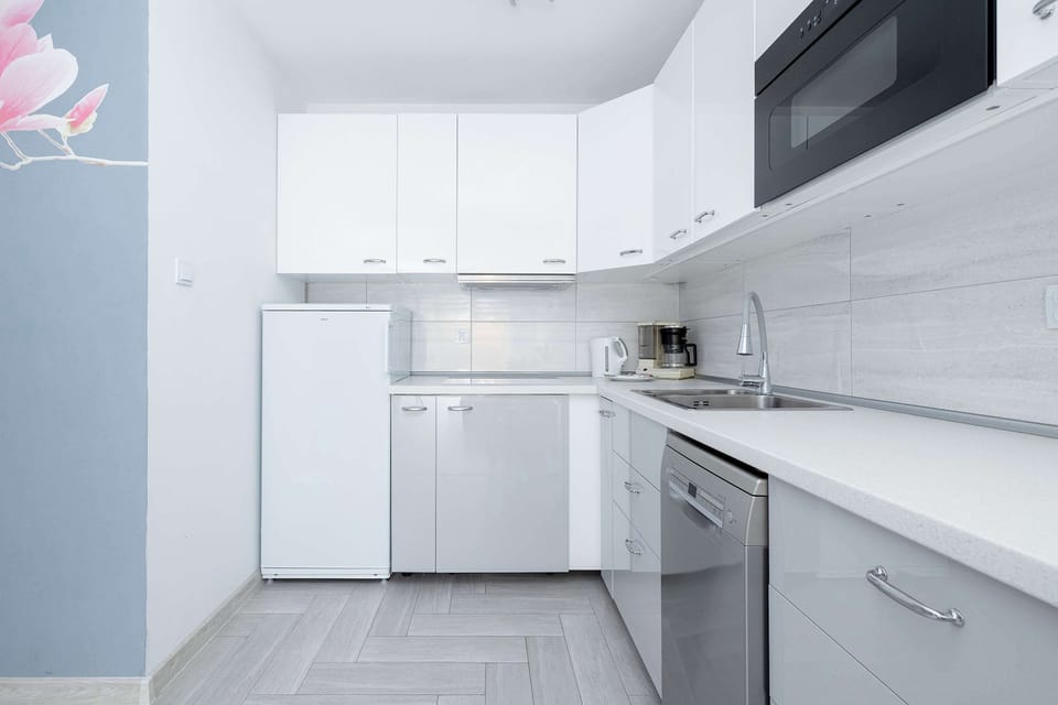 Contemporary kitchen with white cabinets and modern equipment.