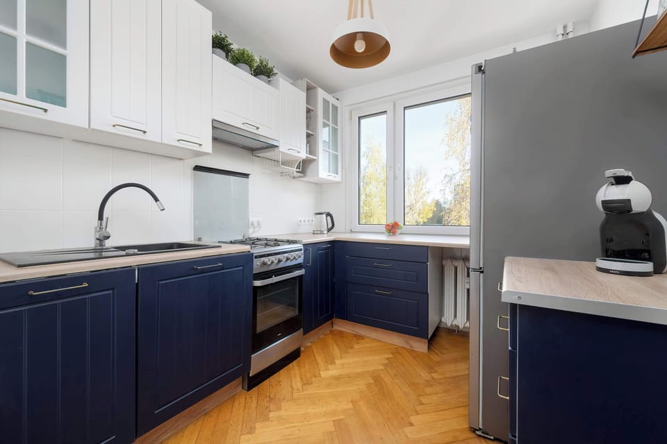 A clean, well-lit kitchen with dark blue cabinetry and a gas stove. The room looks tidy and functional.